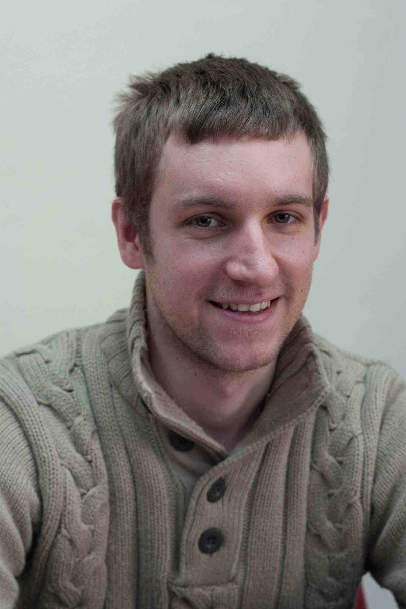 man with a brown sweltered and short hair